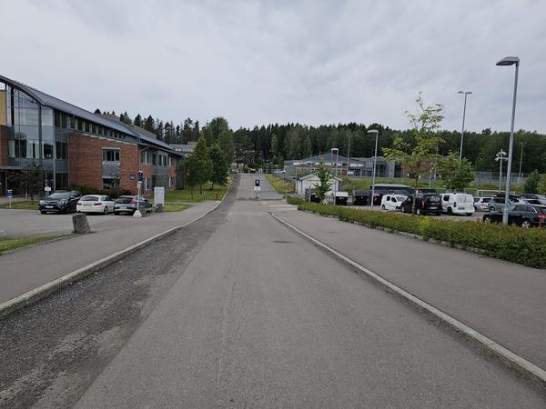 Hovedparkering på høyre side men for de med behov kan det parkeres nærmere. Flerbrukshall skimtes opp til høyre